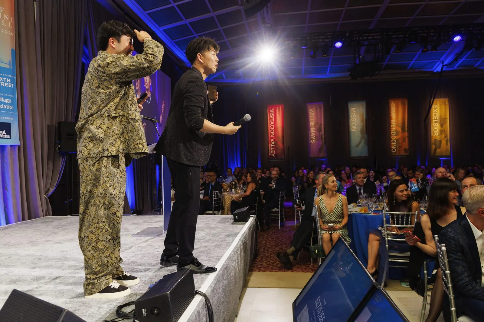 Magician keynote speaker Johnny Wu on stage in front of a full gala ballroom